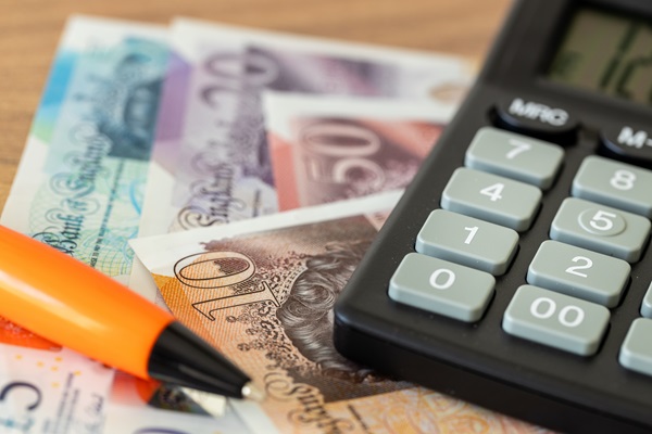 Pound notes and calculator with pen
