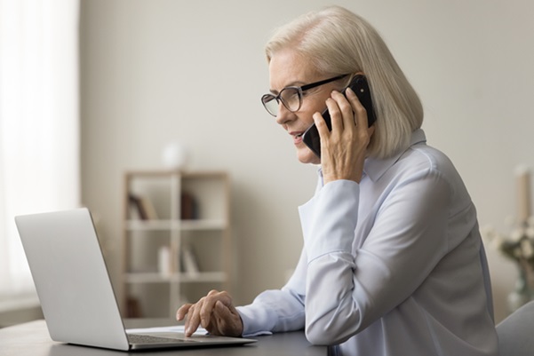 Woman on laptop and phone 600x400