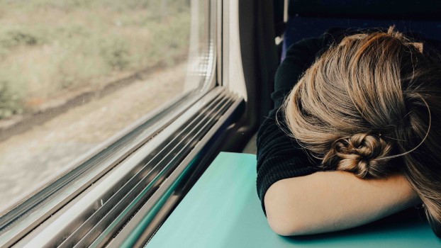 Sleeping woman on train resting her head on her arm