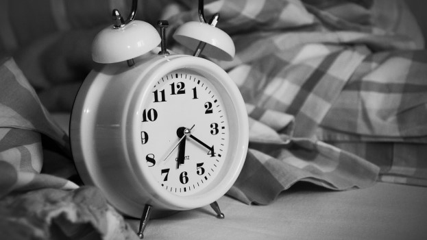 Black-and-white clock next to duvet fatigue lifestyle tips