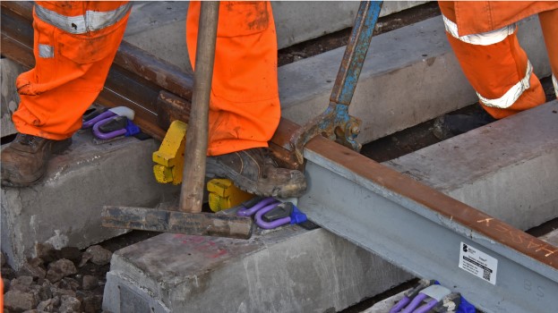 Feet of railway worker working on track