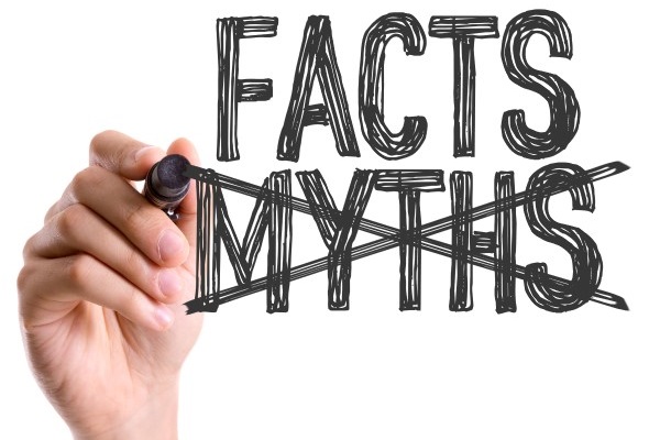 Hand crossing out the word myths and writing facts