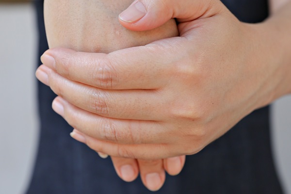 Close-up of a person's hands gently stretching one another.