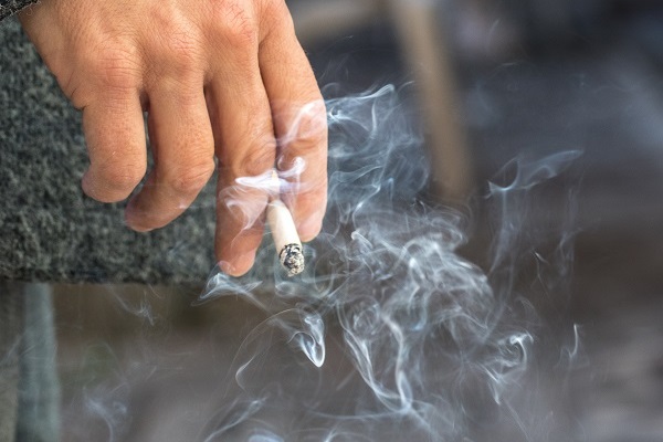 hand with burning cigarette