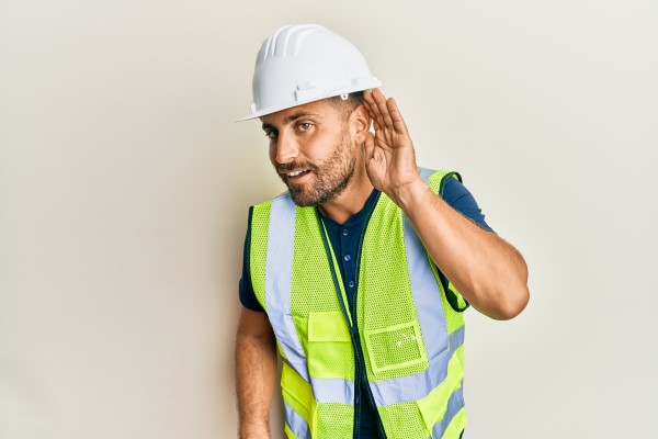 Man in construction PPE listening