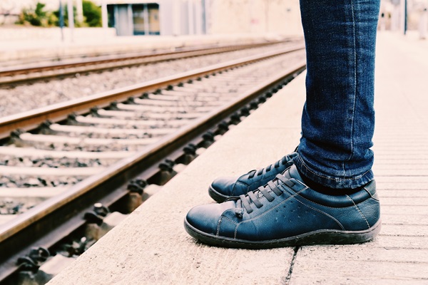 Person standing on the edge of a railway platform