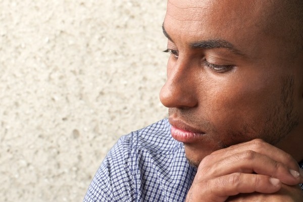Man with his head on his hands looking thoughtful