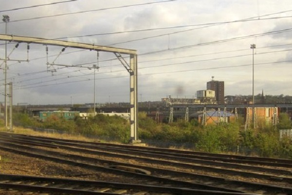 Train tracks curving through an urban landscape under a cloudy sky at Whitehall Junction in Leeds.