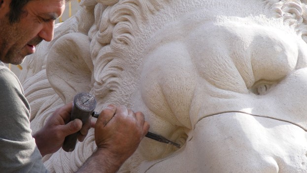 Man carving a stone lion at Chichester Stoneworks