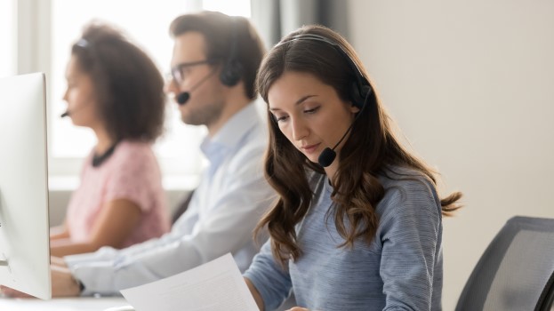 Three people on phone headsets offering customer service to members