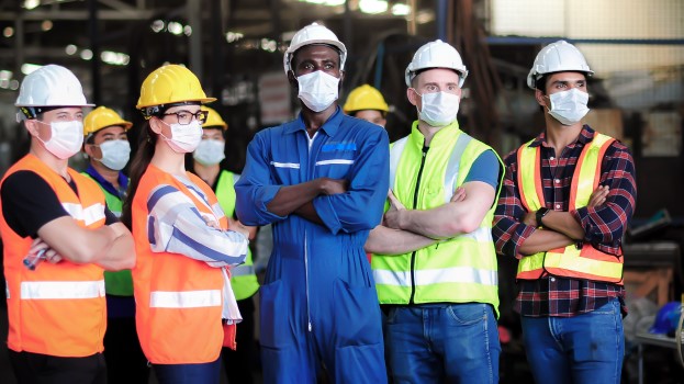 Diverse team in the workplace wearing PPE