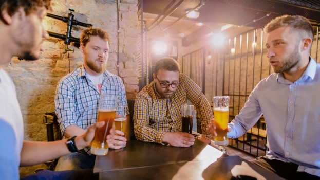 Group of friends chatting in the pub for their wellbeing and to cope with stress