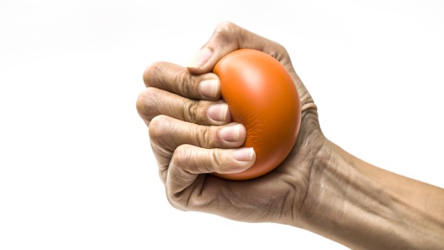 Hand squeezing a red stress ball