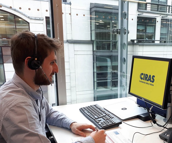 CIRAS reporting analyst wearing headset and sitting at office desk