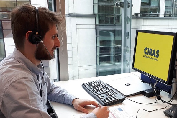 CIRAS reporting analyst wearing headset and sitting at office desk