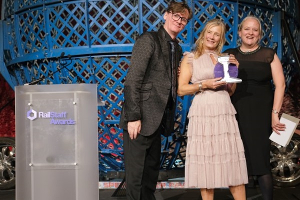 Comedian Ed Byrne (left) and CIRAS' Katie Healy (right) present Great Western Railway's Samantha Winfield (centre) with the Health and Wellbeing Award in the 2022 RailStaff Awards