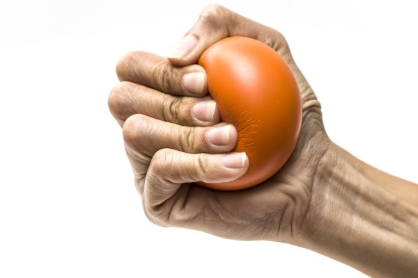 Hand squeezing a red stress ball