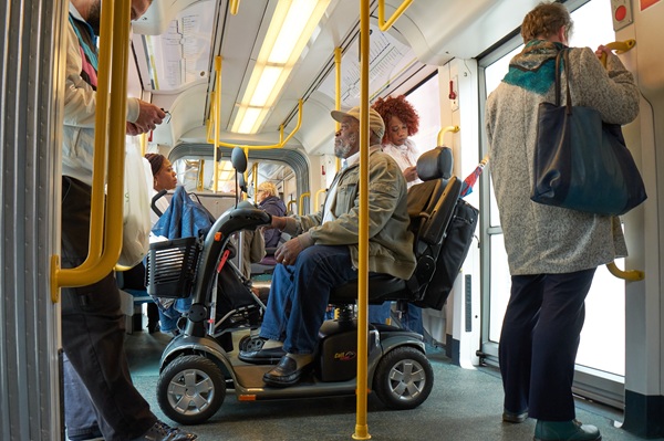 Passengers on an accessible bus including a man in an electric motorised wheelchair